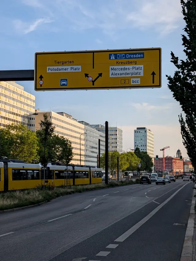 Straße mit Straßenbahn und Wegweiser Richtung Alexanderplatz und Potsdamer Platz